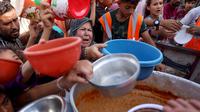 Warga Palestina menerima makanan di sekolah yang dikelola PBB di Rafah, di Jalur Gaza selatan pada 23 Oktober 2023. (Mohammed Abed/AFP)