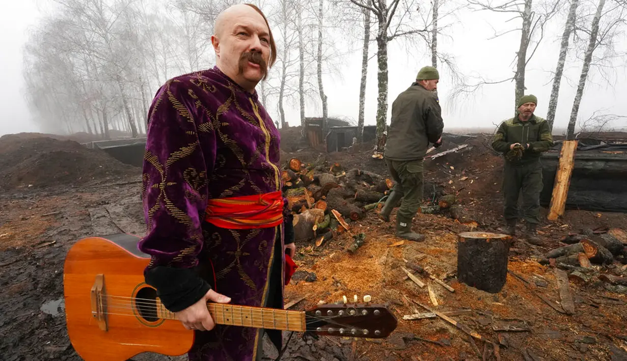 Seorang seniman yang berpakaian Cossack memegang gitarnya usai tampil untuk tentara Garda Nasional Ukraina saat memperingati Natal dekat perbatasan Rusia di Kharkiv, Ukraina, 24 Desember 2022. Pasukan pertahanan Ukraina telah memukul mundur serangan Rusia dekat 19 permukiman di wilayah seperti Sumy, Kharkiv, Donetsk, dan Luhansk selama beberapa hari terakhir. (AP Photo/Andrii Marienko)
