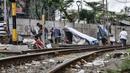 Sejumlah tunawisma beraktivitas di dekat gubuknya yang berada di bantaran rel kereta api kawasan Senen, Jakarta, Minggu (14/2/2021). Setelah sempat ditertibkan, puluhan bangunan semipermanen yang beratapkan terpal dan beralas kardus milik tunawisma kembali menjamur. (merdeka.com/Iqbal S. Nugroho)