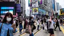 Pejalan kaki mengenakan masker sebagai tindakan pencegahan Covid-19 saat berjalan di Hong Kong (13/5/2020). Dua orang di Hong Kong dinyatakan positif Covid-19, mengakhiri perjalanan 24 hari tanpa kasus baru yang mulai melonggarkan peraturan jarak sosial. (AFP/Anthony Wallace)