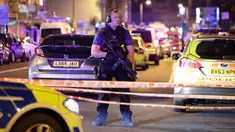 Seorang perwira polisi bersenjata melakukan penjagaan di kawasan Finsbury Park, utara London usai insiden kendaraan yang menabraki pejalan kaki, Senin (19/6). Beberapa orang tewas dan seorang ditangkap terkait insiden tersebut. (Yui Mok/PA via AP)