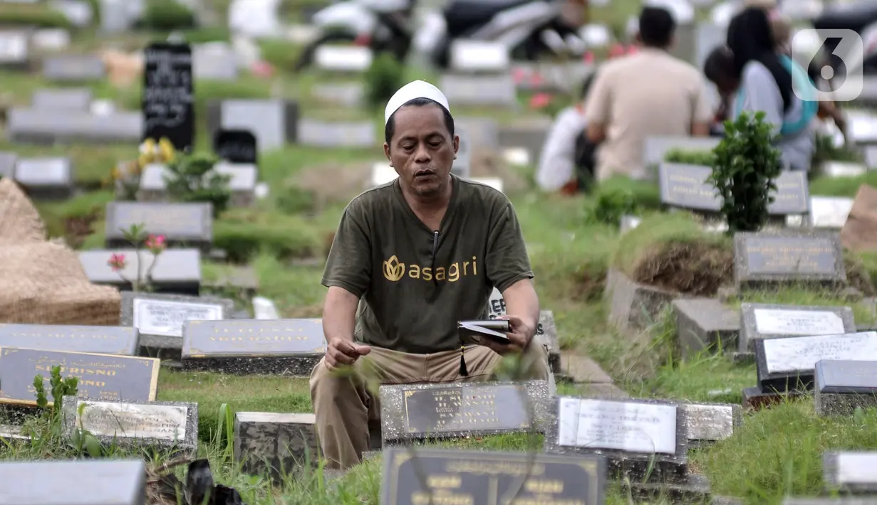 Warga memanjatkan doa saat berziarah ke makam kerabat di Taman Pemakaman Umum (TPU) Kemiri, Rawamangun, Jakarta, Minggu (23/4/2023). (merdeka.com/Iqbal S. Nugroho)