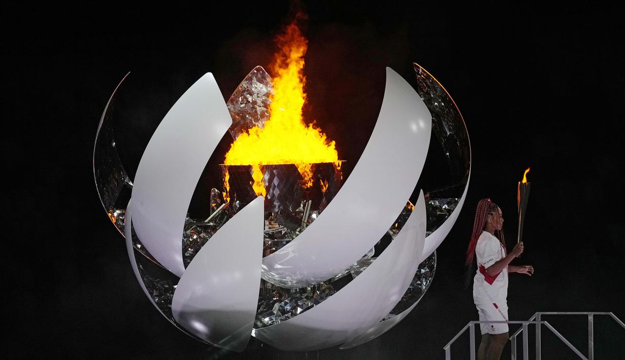 Petenis putri Naomi Osaka menjadi pembawa obor terakhir yang menyulut api Olimpiade ke kaldron. Penyalaan api Olimpiade tersebuti menjadi puncak dari upacara pembukaan Olimpiade Tokyo 2020. (Foto: AP/David J. Phillip)