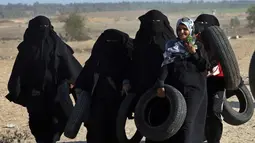 Pengunjuk rasa wanita Palestina membawa ban untuk dibakar saat bentrokan dengan tentara Israel di Khan Younis, perbatasan Gaza, Jumat (10/8). (AP Photo/Adel Hana)