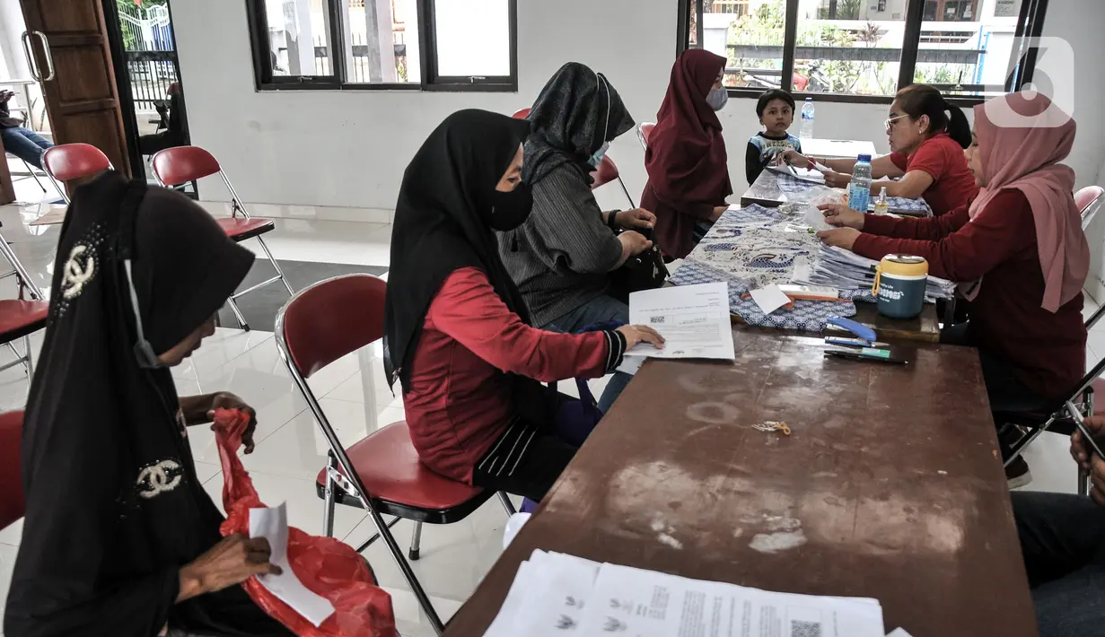 Warga mengurus penyaluran Bantuan Langsung Tunai (BLT) Bahan Bakar Minyak (BBM) tahap tiga di Sasana Krida Karang Taruna (SKKT) Kelurahan Pondok Kopi, Kecamatan Duren Sawit, Jakarta Timur, Kamis (22/9/2022). Sebanyak 771 warga di Kecamatan Duren Sawit menerima manfaat BLT tahap tiga sebesar Rp 300 ribu sebagai kompensasi dari naiknya harga BBM. (merdeka.com/Iqbal S. Nugroho)