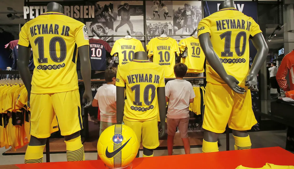 Dua orang anak memilih jersey pemain baru Paris Saint Germain, Neymar Jr, di toko merchandise di Paris, Jumat (4/8/2017). Setelah resmi bergabung dengan Paris Saint Germain, jersey Neymar Jr langsung diburu suporter klub Ibu kota. (AP/Michel Euler)