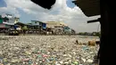 Teresita Gapayao (51) diantara tumpukan sampah di aliran Sungai Estero de Vitas di Tondo, Manila, Filipina, Kamis (21/4). Teresita sudah 12 tahun menafkahi keluarganya dari sampah-sampah yang bisa di daur ulang. (Noel CELIS/AFP)