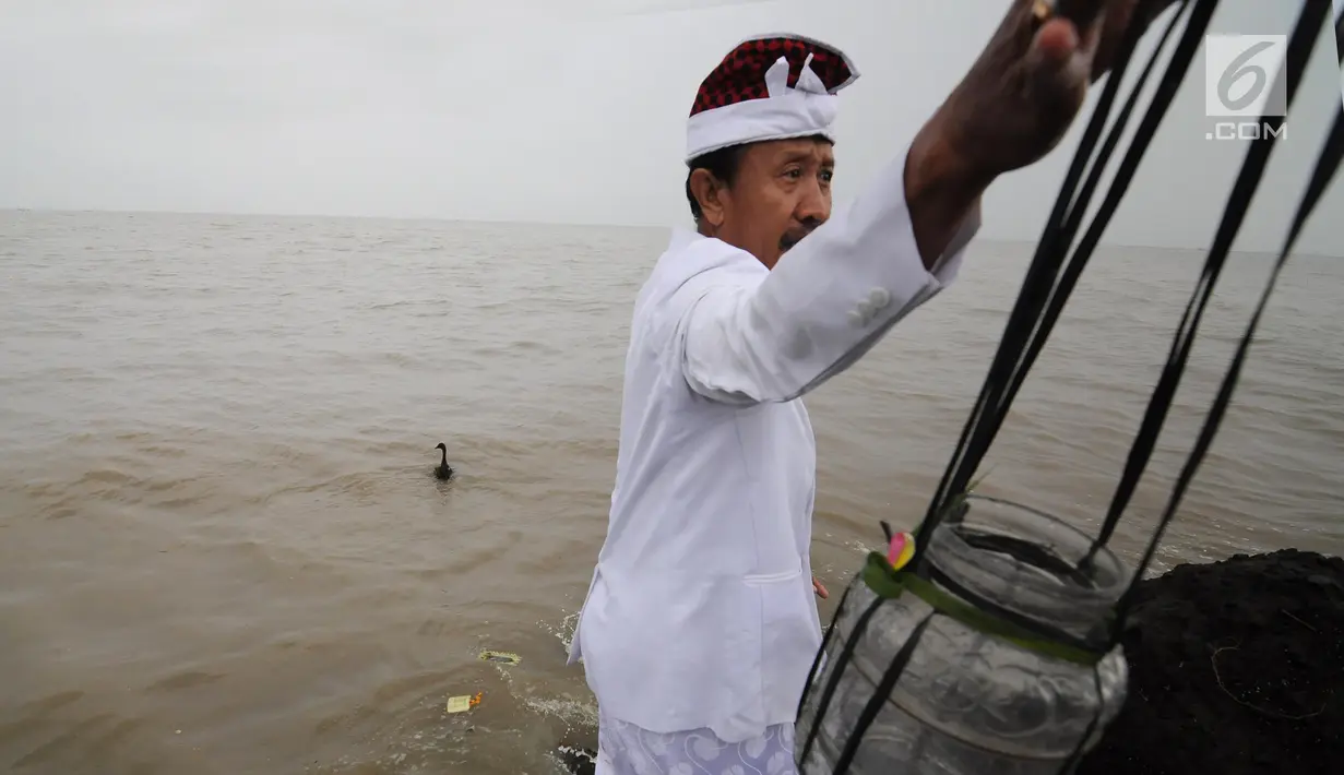 Pemuka agama Hindu melemparkan angsa ke laut saat melaksanakan ritual Melasti di Kawasan Pantai Marina, Semarang, Jawa Tengah, Minggu (11/3). Melasti bertujuan untuk membersihkan diri dari segala bentuk perbuatan buruk di masa lalu. (Liputan6.com/Gholib)