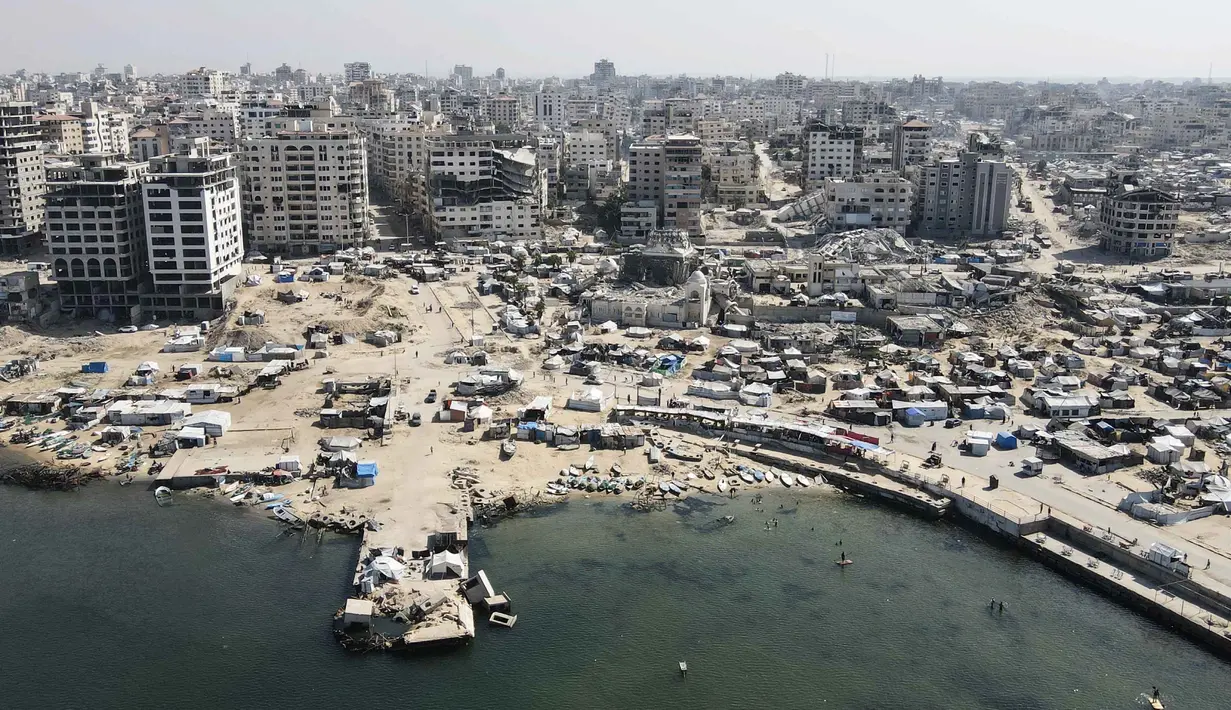 Selama dua tahun terakhir, sejak serangan Israel yang dimulai Oktober 2023, wilayah Gaza berubah menjadi episentrum kehancuran. Tampak dalam foto dari udara yang memperlihatkan tenda-tenda yang menampung pengungsi Palestina di kawasan yang rusak akibat perang di sekitar pelabuhan Kota Gaza pada 20 Oktober 2025, selama gencatan senjata yang dimediasi oleh Amerika Serikat antara Israel dan faksi-faksi Palestina. (Foto oleh AFP)