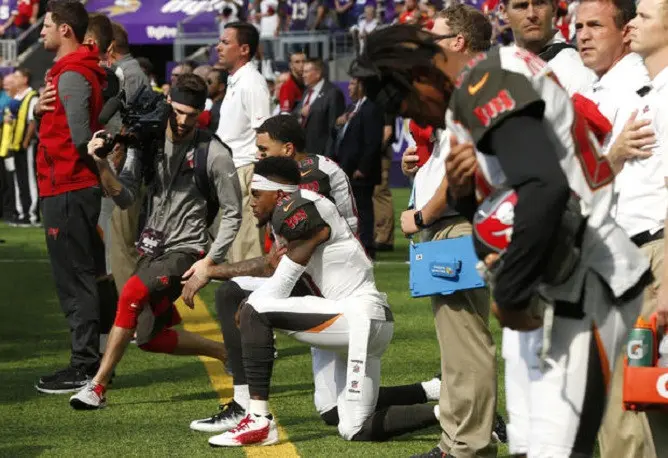 Sebagai bentuk kecaman atas merebaknya sentimen rasisme di AS, sejumlah pemain NFL melakukan aksi protes dengan menolak memberikan penghormatan dan memilih berlutut atau berangkulan saat lagu kebangsaan AS diputar jelang pertandingan. (AP)