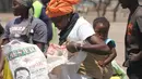 Seorang wanita mengambil bantuan makanan dari World Food Programme di Chiredzi Mupinga, Zimbabwe, Selasa (6/10). Puluhan juta orang di wilayah sub-Sahara Afrika akan mengalami kelaparan akibat siklus El Nino mencapai puncaknya. (REUTERS/Philimon Bulawayo)