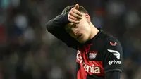 Pemain Bayer Leverkusen, Florian Wirtz menyeka keringat di dahinya saat laga leg kedua 16 besar Liga Europa 2023/2024 melawan Qarabag di BayArena, Leverkusen, Jerman, Jumat (15/03/2024) dini hari WIB. (AFP/Ina Fassbender)