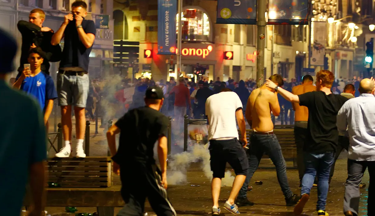 Sejumlah suporter Inggris berlarian setelah petugas menembakkan gas air mata di Kota Lille, Prancis, (15/6). UEFA mengancam akan mendiskualifikasi tim Inggris dari Piala Eropa 2016 jika para suporter membuat kerusuhan kembali. (REUTERS/Wolfgang Rattay)