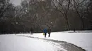Orang-orang berjalan saat salju menutupi kota pada hari musim semi, di Pamplona, Spanyol utara (2/4/2022). Pihak berwenang mengumumkan suhu rendah untuk hari-hari berikutnya. (AP Photo/Alvaro Barrientos)