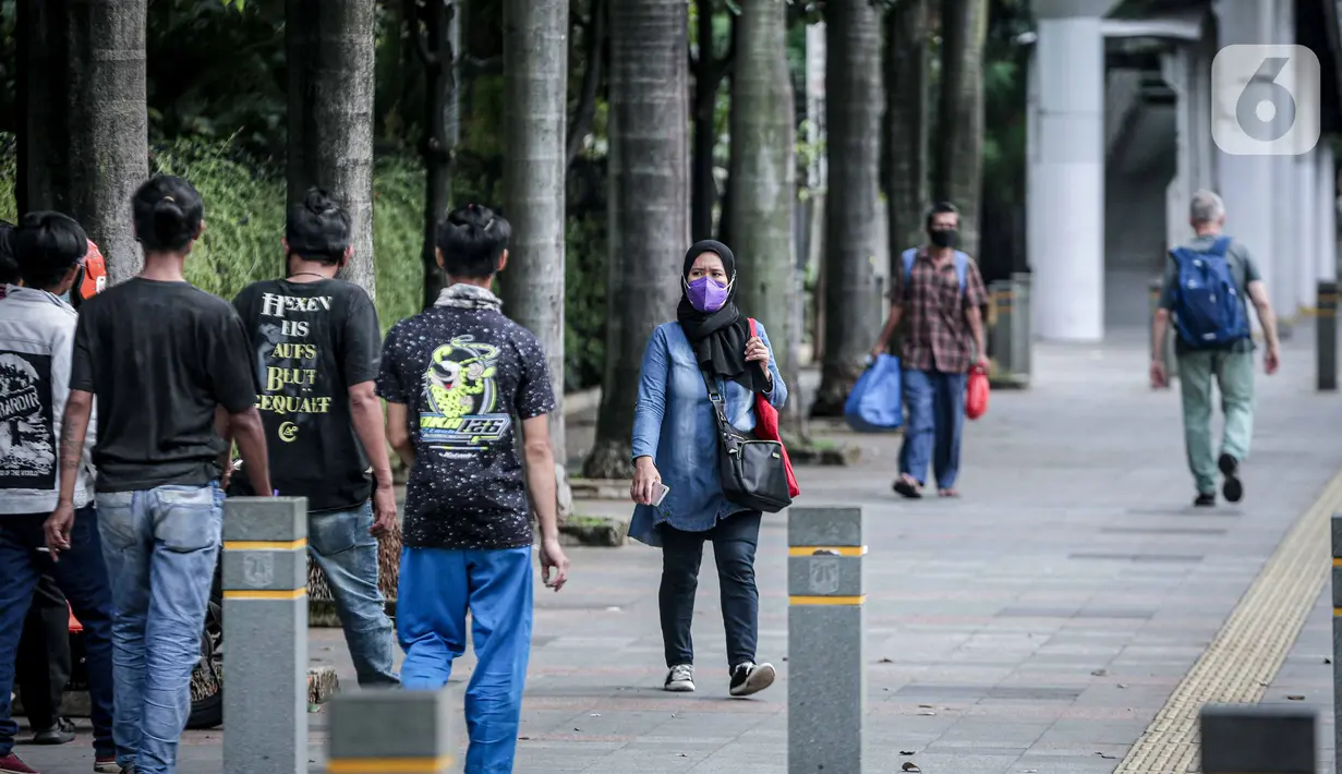 Sejumlah warga berjalan di Kawasan Sudirman, Jakarta, Kamis, (17/2/2022). Kepala BPBD DKI Jakarta Isnawa Adji mengatakan, Menteri Kesehatan (Menkes) Budi Gunadi Sadikin sudah memberikan sinyal bahwa DKI telah melewati pandemi gelombang ketiga. (Liputan6.com/Faizal Fanani)