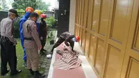 Petugas ber-APD lengkap mengevakuasi jenazah tukang becak yang meninggal dunia mendadak di Purwokerto. (Foto: Liputan6.com/Tagana Banyumas/Muhamad Ridlo)