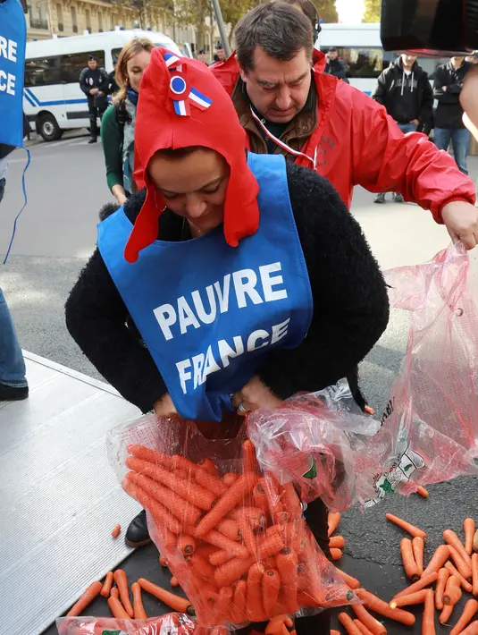 Demonstran membuka plastik berisi wortel ke jalanan depan kantor Kementerian Kesehatan di Paris, Rabu (4/10). Harga sebungkus rokok diperkirakan naik menjadi sekitar Rp 160 ribu perbungkus dari harga awal Rp 110 ribu. (AFP PHOTO/JACQUES DEMARTHON)