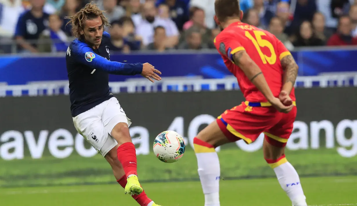 Penyerang Prancis, Antoine Griezmann menendang bola dari kawalan pemain Andorra, Moises San Nicolas pada pertandingan grup H Kualifikasi Euro 2020 di Stade de France di Saint Denis, Paris (10/9/2019). Prancis menang telak 3-0 atas Andorra. (AP Photo/Michel Euler)