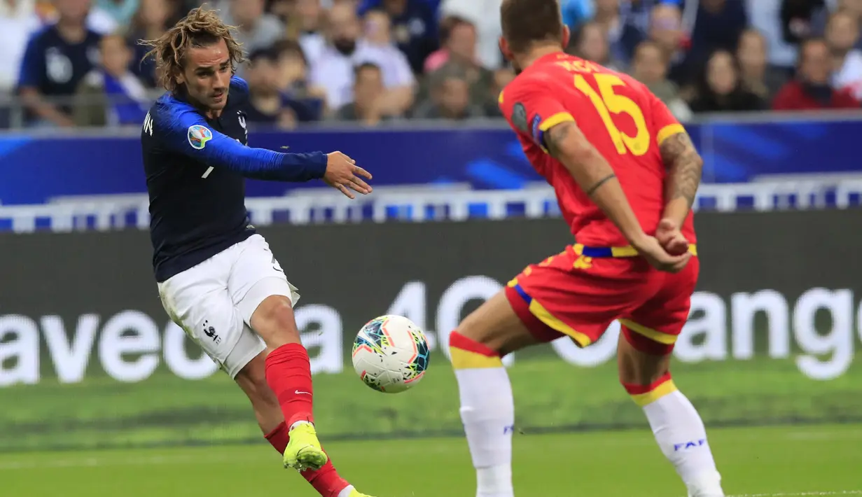 Penyerang Prancis, Antoine Griezmann menendang bola dari kawalan pemain Andorra, Moises San Nicolas pada pertandingan grup H Kualifikasi Euro 2020 di Stade de France di Saint Denis, Paris (10/9/2019). Prancis menang telak 3-0 atas Andorra. (AP Photo/Michel Euler)