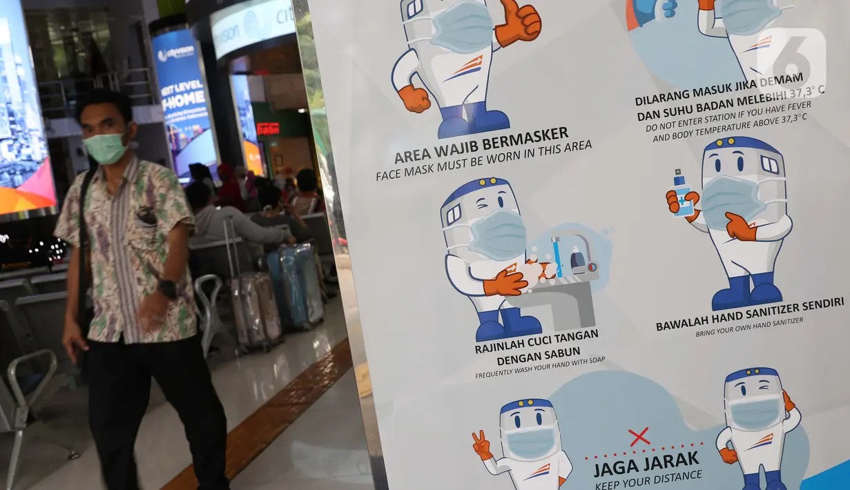 Papan sosialisasi pencegahan penularan virus COVID-19 di Stasiun Gambir, Jakarta, Rabu (16/12/2020). 47 KA jarak jauh yang dioperasikan selama masa Nataru 2020/2021 terdiri dari, 22 KA dari Stasiun Gambir, 23 dari Stasiun Pasar Senen, dan dua dari Jakarta Kota. (Liputan6.com/Helmi Fithriansyah)