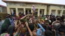 <p>Seorang sukarelawan membagikan makanan kepada anak-anak di sebuah kamp yang didirikan di gedung sekolah untuk para pengungsi internal dari daerah pesisir saat Topan Biparjoy mendekat di Badin, Provinsi Sindh, Pakistan, Kamis (15/6/2023). India dan Pakistan yang menderita banjir mematikan tahun lalu bersiap untuk banjir baru saat Topan Biparjoy mendekat dengan cepat. (AP Photo/Fareed Khan)</p>