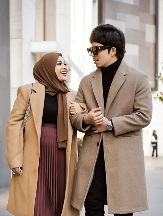 Masih senada, namun dalam palet warna yang lebih netral, Aurel tampil kenakan long coat cokelat, yang dipadunya dengan innerwear hitam dan pleated midi skirt berwarna ungu. Sedangkan Atta memberi sentuhan warna cokelat netral pada tampilan serba hitamnya. Foto: Instagram.