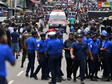 Polisi mensterilkan jalan saat sebuah ambulans melaju membawa korban ledakan gereja di Kochchikade, Kolombo, Sri Lanka, Minggu (21/4). Sekitar 99 orang dilaporkan tewas dalam ledakan di tiga gereja dan tiga hotel di Sri Lanka. (AP Photo/Eranga Jayawardena)