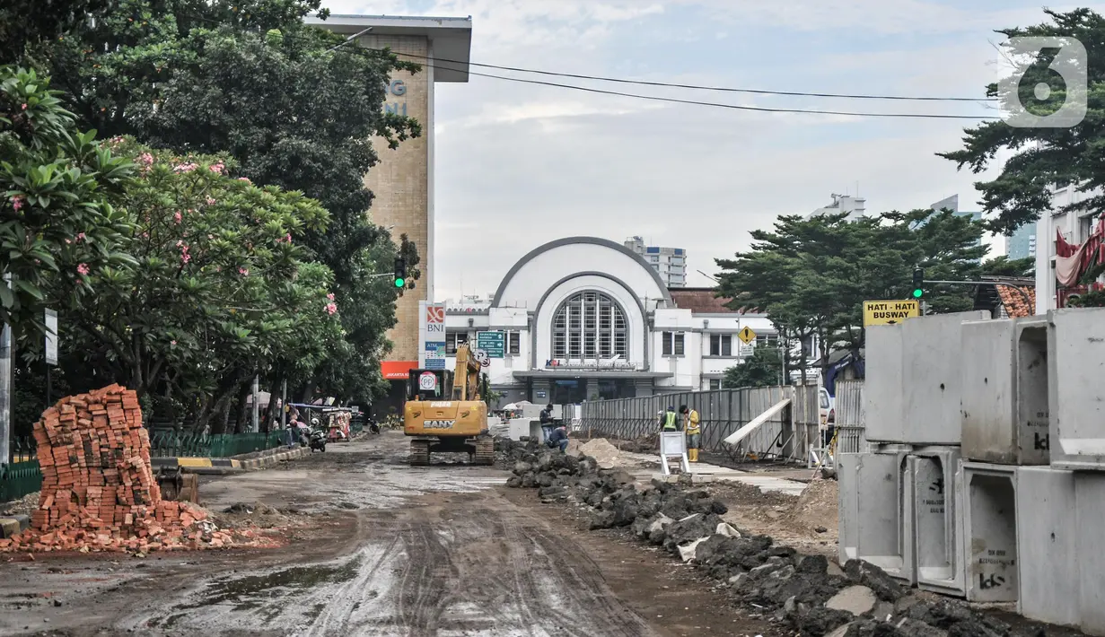 Aktivitas pekerja menyelesaikan proyek revitalisasi fasilitas pejalan kaki atau pedestrian kawasan Kota Tua, Jakarta, Minggu (27/3/2022). Jalur pedestrian itu akan diubah menjadi plaza pedestrian yang lebar sebagai bagian dari penataan kawasan Kota Tua yang rendah emisi (merdeka.com/Iqbal S Nugroho)