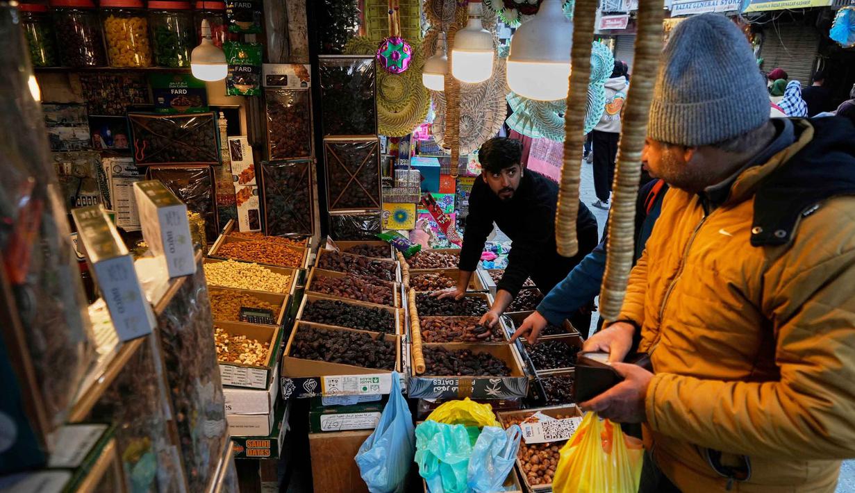 Kandungan karbohidrat sederhana dalam kurma juga mudah diserap tubuh untuk memulihkan kadar gula darah yang menurun selama berpuasa. Tampak dalam foto, umat Muslim Kashmir berbelanja untuk kebutuhan bulan suci Ramadan di sebuah pasar di Srinagar, Rabu 18 Februari 2026. (AP Photo/Mukhtar Khan)