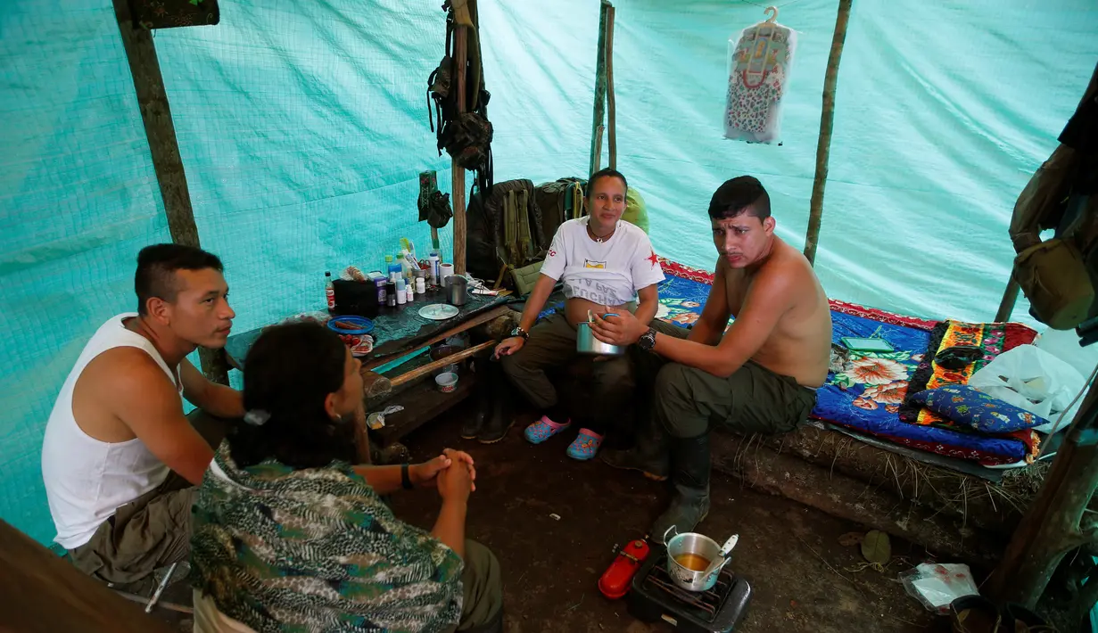 Angkatan Bersenjata Revolusioner Kolombia (FARC) Tatiana, yang sedang hamil enam bulan berbincang dengan suami dan temannya di dalam tenda jelang pengesahan kesepakatan damai dengan pemerintah Kolombia, di Yari Plains (17/9). (REUTERS/John Vizcaino)