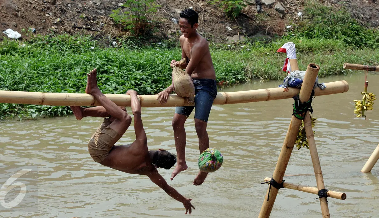 Peserta pukul bantal berusaha menjatuhkan lawannya di Bantaran Kalimalang, Cipinang Melayu, Jakarta, Senin (17/8/2015). Berbagai lomba diadakan dalam rangka memeriahkan perayaan HUT RI ke-70. (Liputan6.com/Johan Tallo)