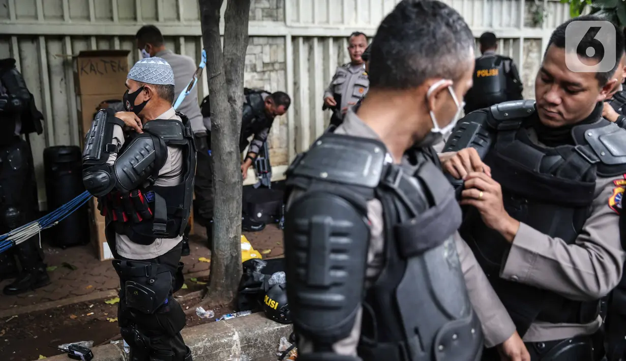 Personel Brimob bersiap mengenakan perlengkapan pelindung diri di Kawasan Bundaran HI, Jakarta, Selasa (13/10/2020). Sebanyak kurang lebih 12 ribu personel gabungan TNI, Polri dan Pemprov DKI Jakarta diterjunkan mengawal aksi tolak Undang-Undang Cipta Kerja Omnibus Law. (Liputan6.com/Faizal Fanani)