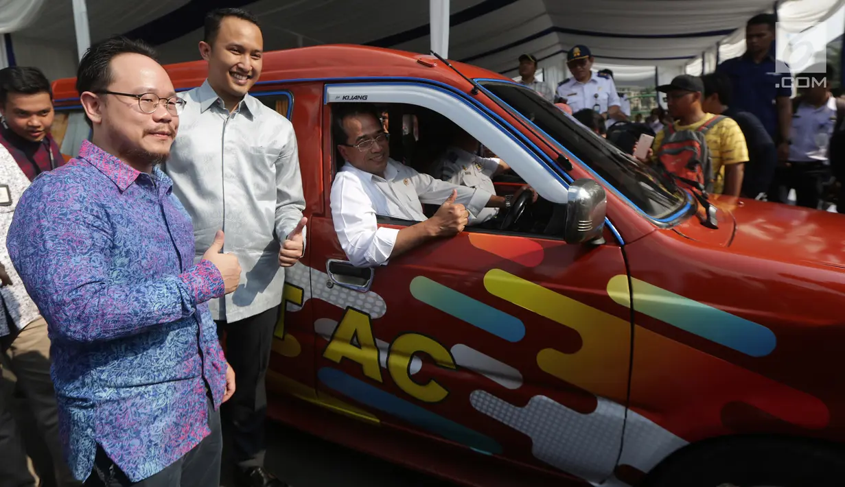 Senior VP Operational GO JEK,Arno Tse, Senior Public Policy Associate Uber, Pandu Adi Laras  dan Menteri Perhubungan Budi Karya Sumadi saat meluncurkan program Angkutan Kota ber-AC di Monas, Jakarta, Sabtu (1/7).(Liputan6.com)