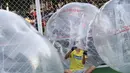 Seorang pemain terlihat mengeluarkan tubuhnya dari dalam sebuah gelembung usai bermain sepakbola di Beijing, Kamis (10/7/14). (REUTERS/Kim Kyung-Hoon)