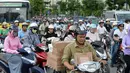 Para pengendara motor melintasi persimpangan jalan di pusat kota Hanoi, 4 Juli 2017. Ibu Kota Vietnam akan melarang sepeda motor di distrik metropolitan mulai 2030 guna mengurangi kemacetan lalu lintas dan polusi. (AFP PHOTO/HOANG DINH Nam)
