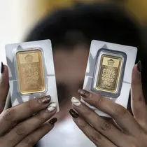 Pramuniaga menunjukkan emas batangan PT Aneka Tambang (Antam) Tbk di sebuah gerai emas, Jakarta, Senin (18/1/2021). Pada hari ini, harga emas Antam turun menjadi Rp 944 ribu per gram. (Liputan6.com/Johan Tallo)