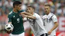 Gelandang Jerman, Thomas Mueller, berusaha merebut bola dari striker Meksiko, Raul Jimenez, pada laga Grup F Piala Dunia di Stadion Luzhniki, Moskow, Minggu (17/6/2018). Meksiko menang 1-0 atas Jerman. (AP/Victor Caivano)