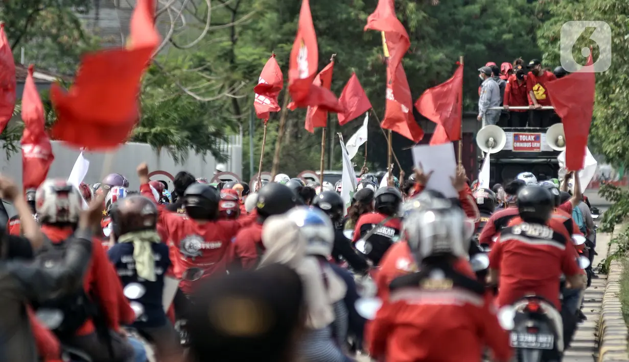 Massa dari berbagai serikat buruh menggelar aksi menolak UU Omnibus Law Cipta Kerja di kawasan JIEP, Jakarta, Selasa (6/10/2020). Ratusan buruh berpawai sambil berorasi mengajak pekerja turun ke jalan menolak UU Omnibus Lawa Cipta Kerja yang dinilai merugikan buruh. (merdeka.com/Iqbal S. Nugroho)