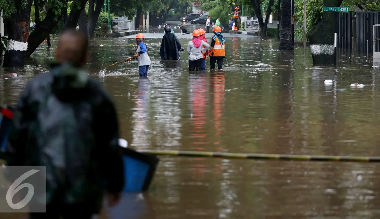 Petugas kebersihan menijau lokasi banjir di kawasan di Hang Lekiu, Kebayoran Baru, Jakarta, Jumat (11/11). Hujan deras yang mengguyur Jakarta sejak siang tadi menyebabkan sejumlah wilayah tergenang banjir. (Liputan6.com/Johan Tallo)