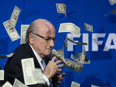 Ekspresi Presiden FIFA, Sepp Blatter, yang terkejut saat seorang pelawak Inggris, Simon Brodkin alias Lee Nelson melemparkan segepok uang dollar sebelum dimulainya konferensi pers di kantor FIFA di Zurich., Swiss. (20/7/2015). (AFP PHOTO/FABRICE COFFRINI)