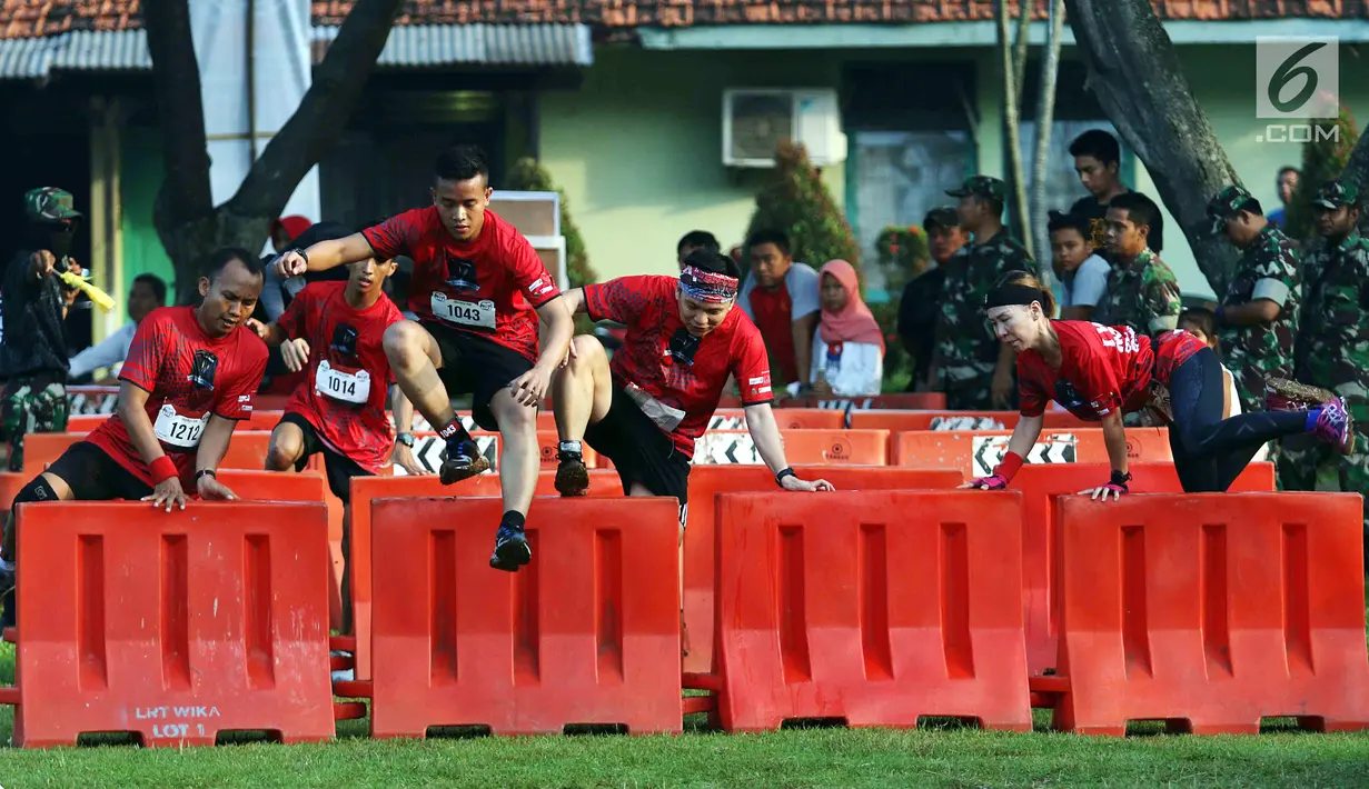 Para peserta melompati aral rintang dalam ajang Komando Warriors II di Kompleks Kopassus Cijantung, Jakarta, Minggu (6/5). Komando Warriors diikuri oleh 650 peserta yang terdiri dari masyarakat umum dan anggota militer. (Liputan6.com/Angga Yuniar)