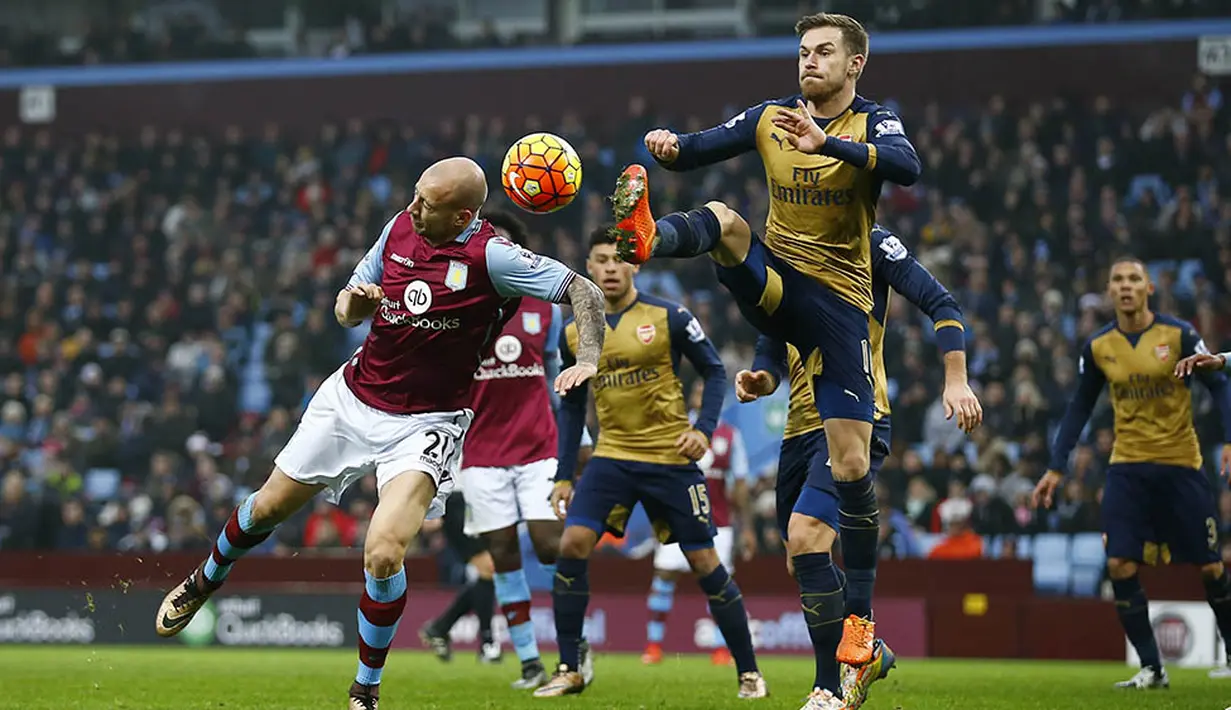 Gelandang Arsenal, Aaron Ramsey, berebut bola dengan pemain Aston Villa, Alan Hutton, pada laga Liga Premier Inggris di Stadion Villa Park, Inggris, Minggu (13/12/2015). (Reuters/Darren Staples)