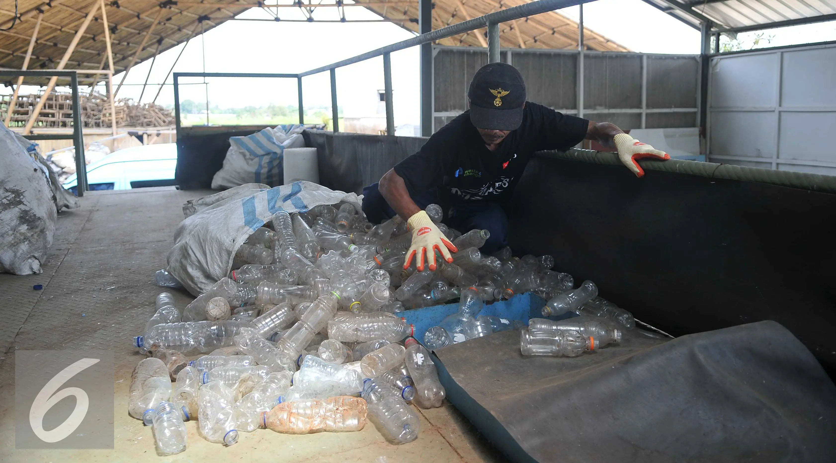 Pekerja memasukan botol plastik kedalam alat potong plastik di Perumahan Vida, Bekasi (19/3). Limbah botol plastik dimanfaatkan menjadi bahan mentah yang bernilai ekonomis dan mengurangi dampak pencemaran lingkungan. (Liputan6.com/Gempur M Surya)