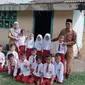 Murid dan guru SDN 002 Tanjung, Kabupaten Kampar yang terpaksa belajar di bekas WC karena keterbatasan ruangan. (Liputan6.com/M Syukur)
