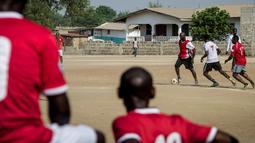 Pemain muda Liberia menonton saat mantan bintang Liberia, George Weah, bermain dalam sebuah pertandingan di Alpha Old Timers Sports Association di Monrovia, Liberia, (30/4/2016). (AFP/Marco Longari)