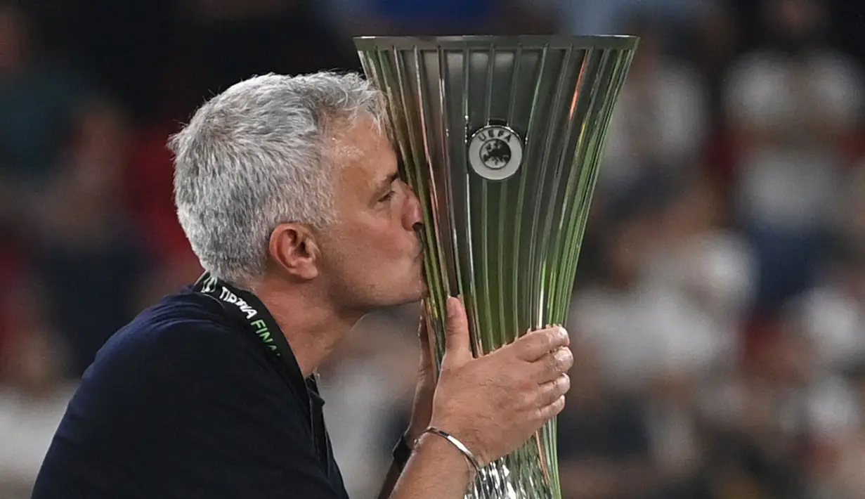 Pelatih kepala AS Roma, Jose Mourinho mencium trofi EUFA Confernce League usai berhasil membawa AS Roma mengalahkan Feyenoord dengan skor 1-0 pada laga final yang berlangsung di Stadion Arena Kombetare Tirana, Albania, pada Kamis (26/5/2022) dini hari WIB. Bagi Mourinho, trofi ini menjadi gelar juara Eropa-nya yang kelima. (AFP/Ozan Kose)