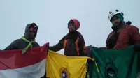 Tiga mahasiswa Unsri mengibarkan Bendera Merah Putih, Bendera Unsri dan Bendera Mafesripala diatas Puncak Cartenz (Liputan6.com/Nefri Inge)