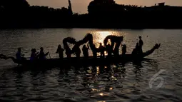 Sejumlah peserta memainkan naga liong saat melintasi Sungai Cisadane dalam rangka Festival Cisadane 2015, Banten, Sabtu (2305/2015). Sebanyak 100 perahu nusantara menampilkan berbagai pernak-pernik budaya khas nusantara (Liputan6.com/Andrian M Tunay)