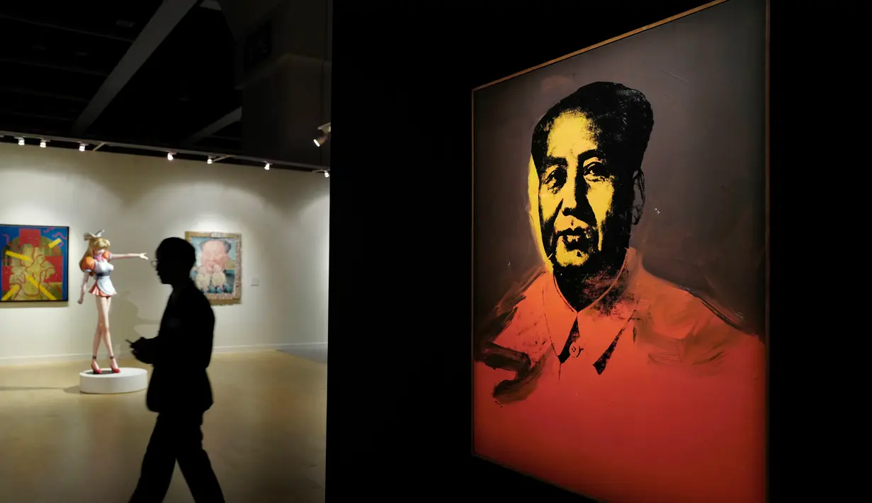 Pengunjung berjalan di samping lukisan Zedong karya seniman Andy Warhol di Sotheby’s Modern and Contemporary Art Evening Sale, Hongkong, Jumat (31/3). Lukisan ini diharapkan bisa laku seharga USD 15 juta (sekitar Rp 200 miliar). (AP Photo / Vincent Yu)