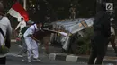Massa melemparkan batu ke arah barisan polisi dalam unjuk rasa di sekitaran Gedung DPR RI, Jakarta, Senin (30/9/2019). Kericuhan pecah lantaran massa yang kebayakan terdiri dari pelajar tersebut berusaha masuk ke area depan DPR. (Liputan6.com/Johan Tallo)
